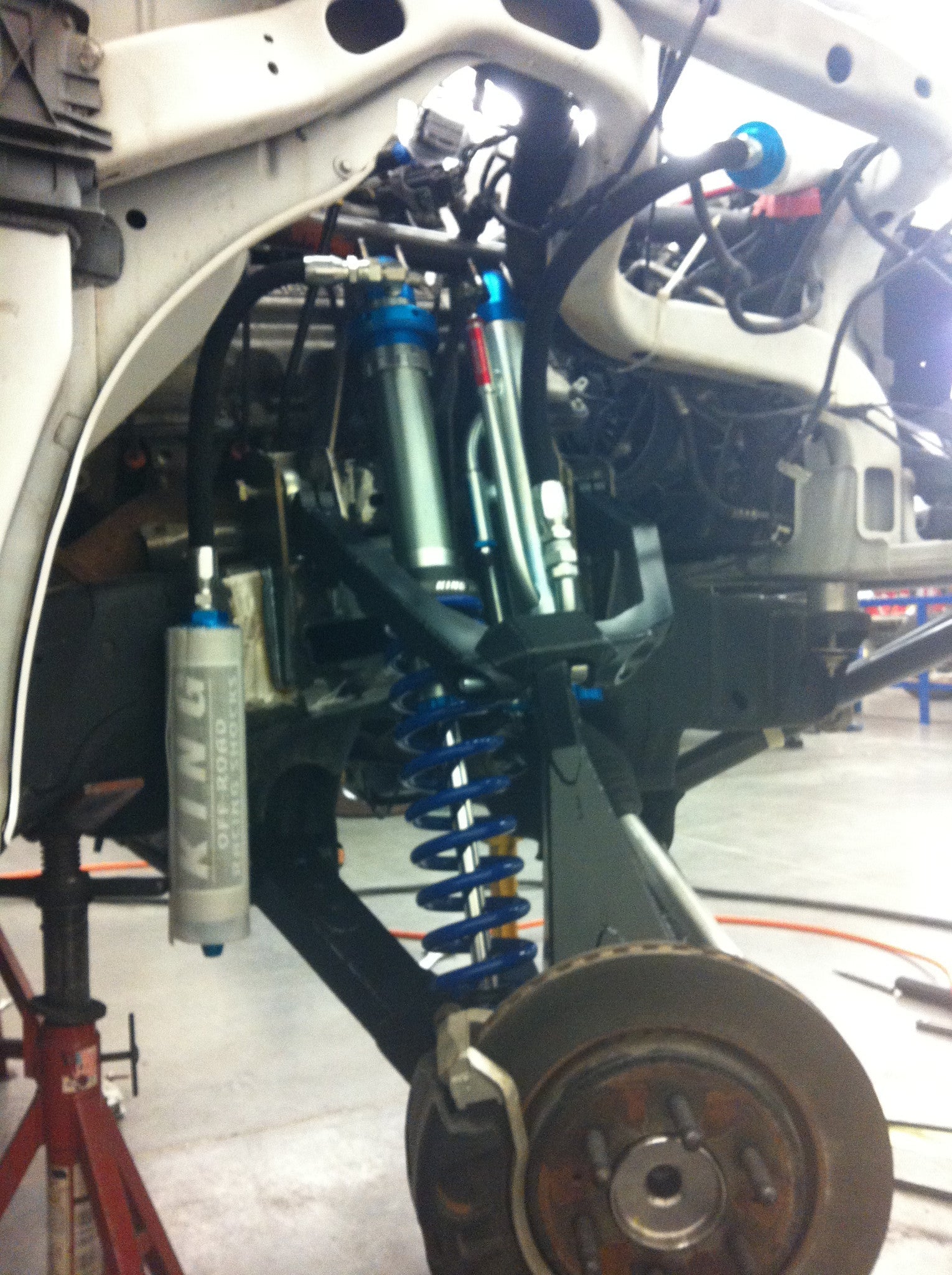 Long travel front suspension kit for 2010-2014 Raptor, showcasing shock absorbers and coil springs for enhanced offroad performance.