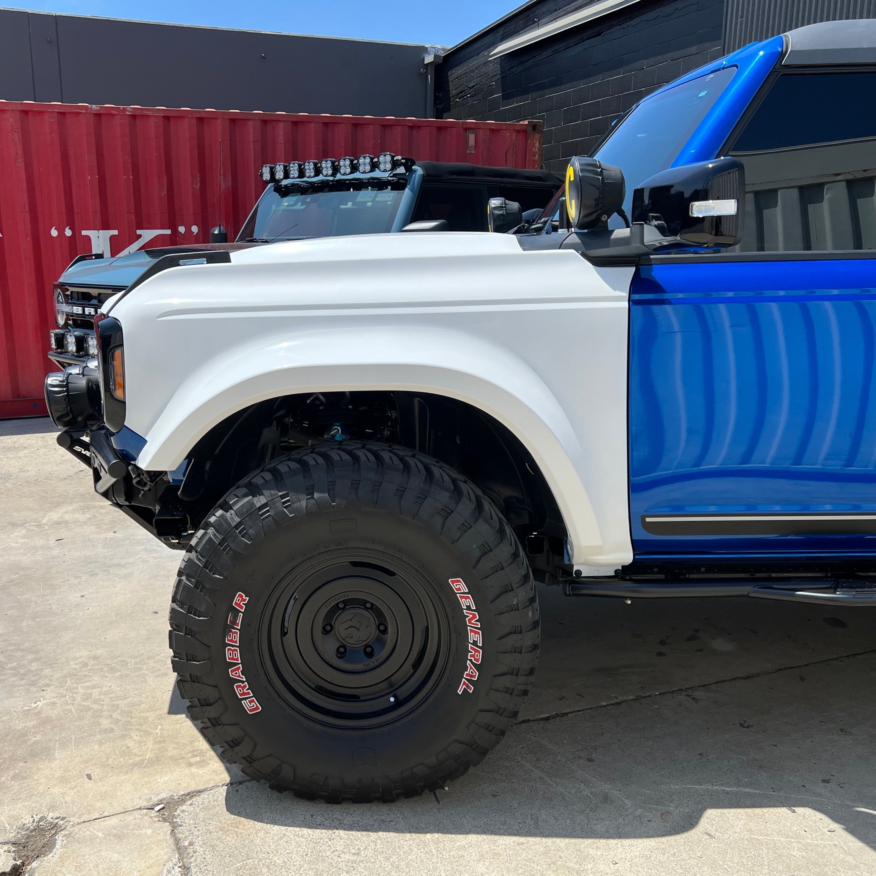 2021-2022 Ford Bronco fenders showcasing a custom blue and white design with oversized tires and offroad features.