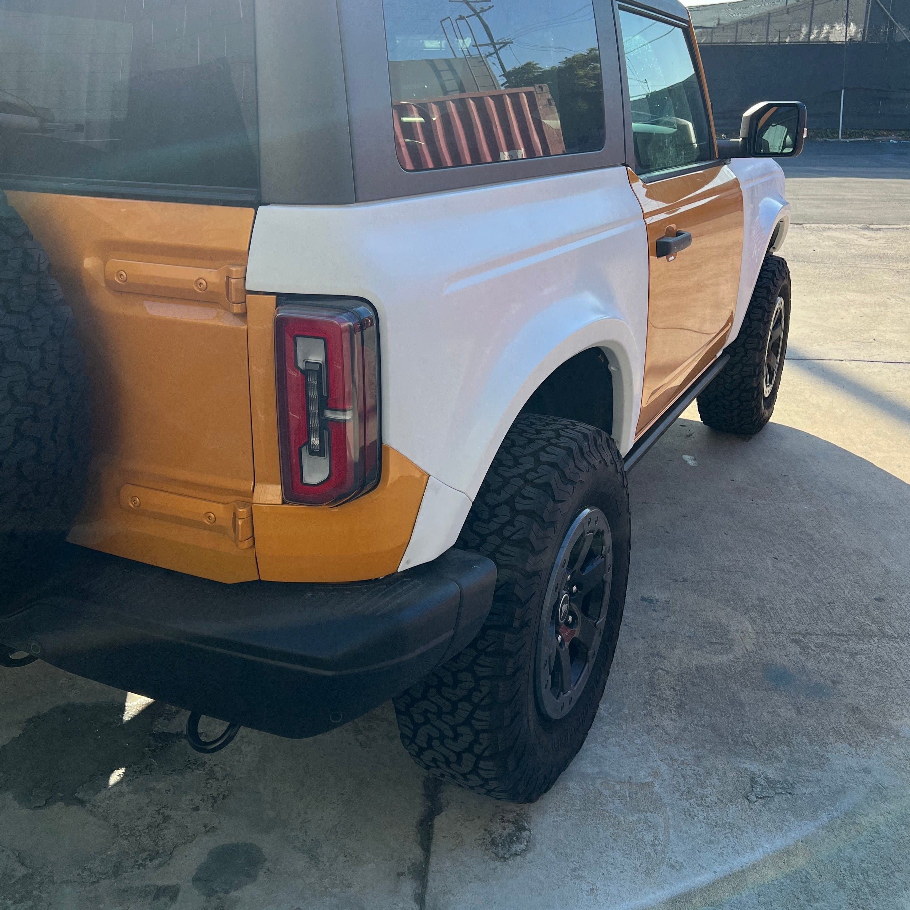 2021-2022 Ford Bronco 2-Door Rear Quarter Kit showcasing a custom orange and white design on a rugged offroad vehicle.