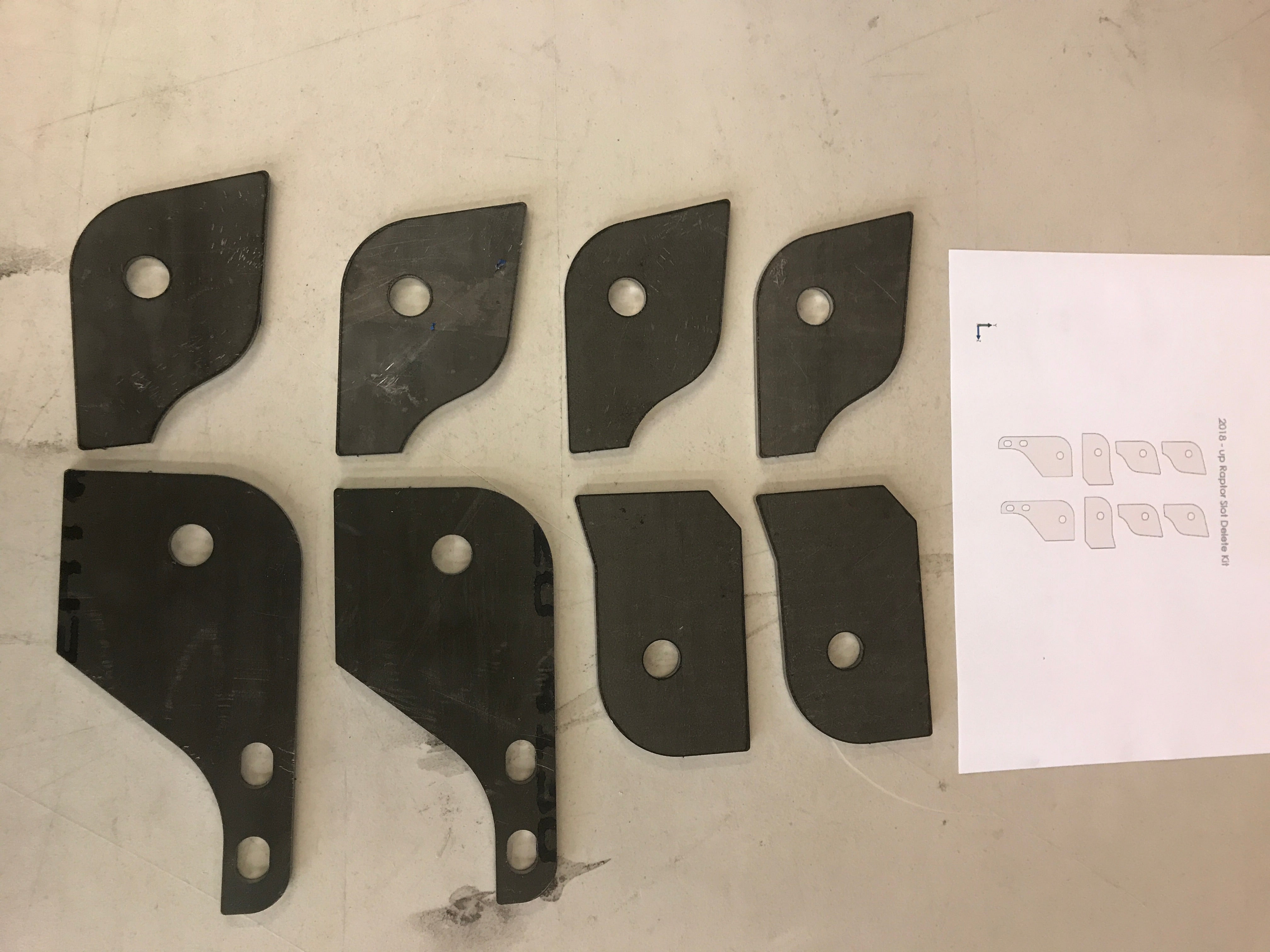 Weld-in plate kit for 2017 and newer Raptor lower arm slot delete, includes multiple plates for installation.