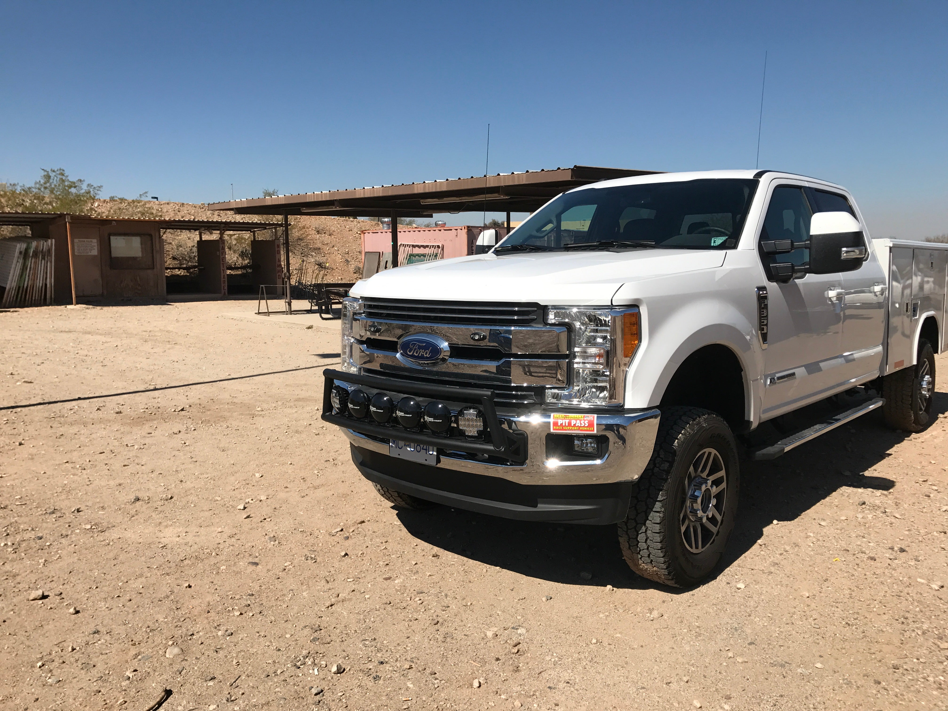 Light mount kit for 2017-2020 Ford Super Duty installed on a truck with a stock front bumper in a desert setting.