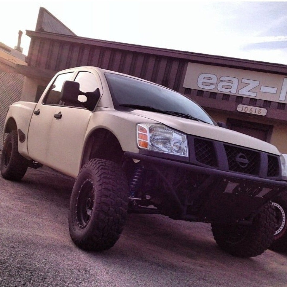 2004-2014 Nissan Titan with custom bedsides, showcasing an offroad-ready stance and rugged tires in a desert setting.