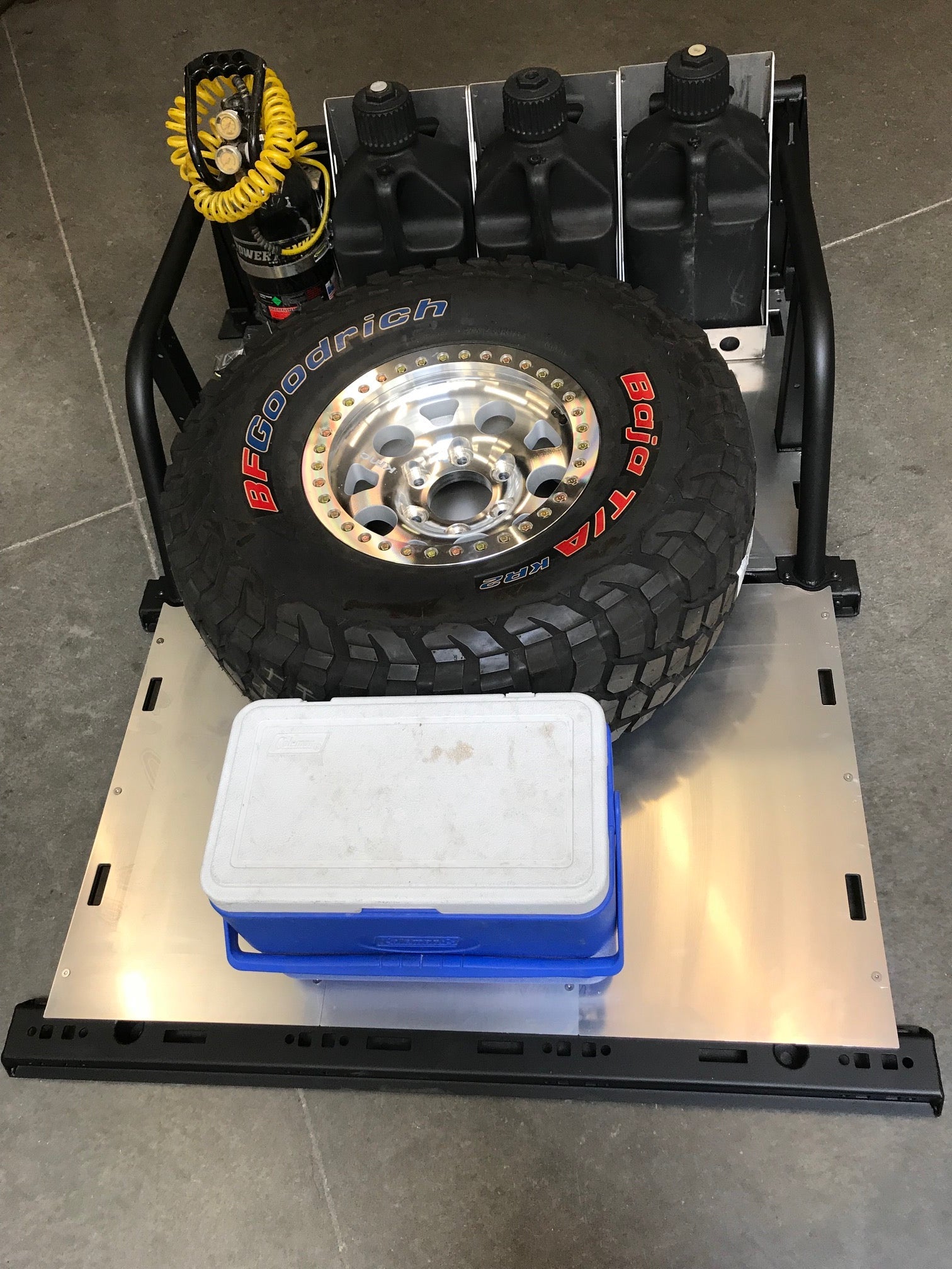 Modular bed organizer for 2017-2024 Ford Raptor and F150, featuring a tire, storage containers, and tool mounts.