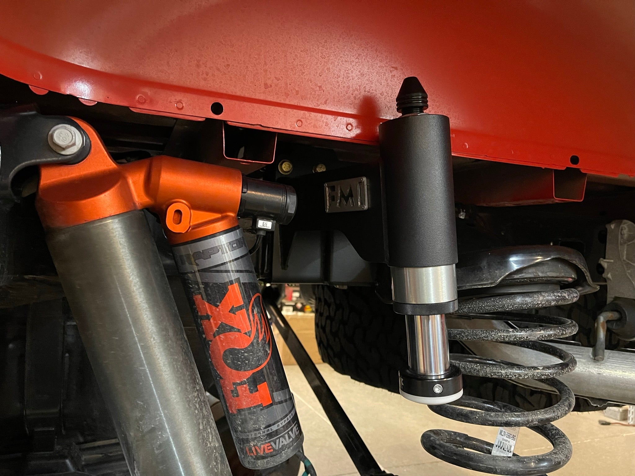2021-2024 Ford Raptor rear bump stop kit installed, showcasing shock absorber and suspension components for offroad performance.