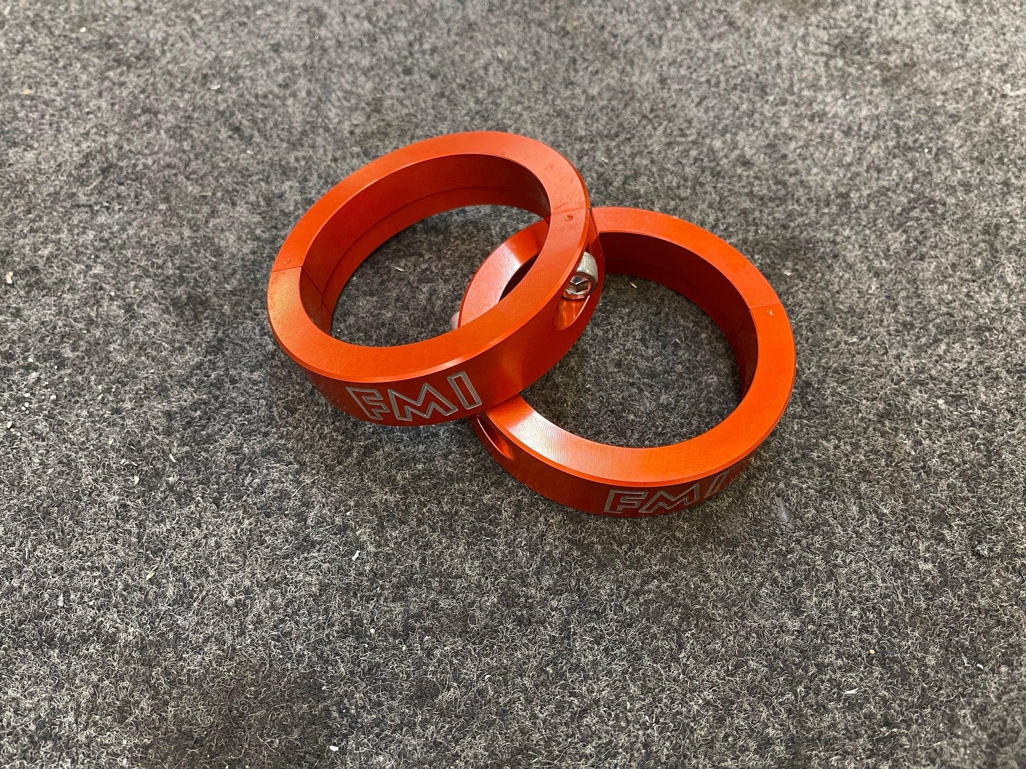 2021 and up Raptor front leveling kit featuring 2-inch and 1.5-inch lift spacers in vibrant orange aluminum.