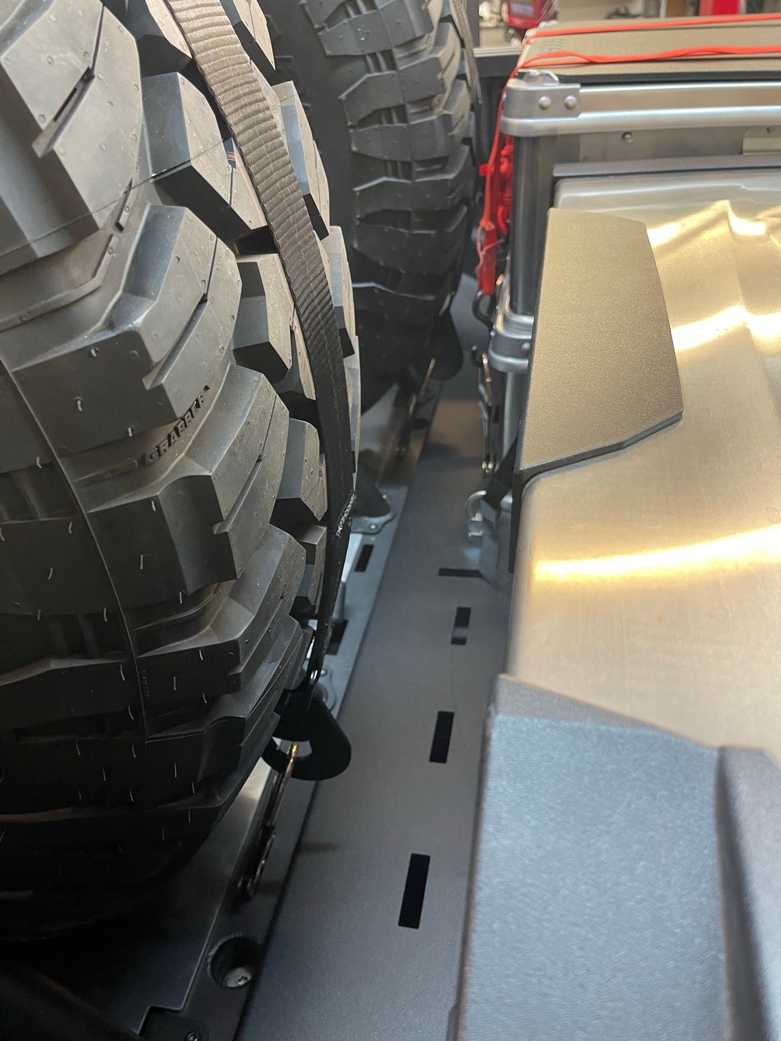 Modular bed organizer for 2017-2024 Ford Raptor featuring a slide-out cargo tray and secure tire storage.