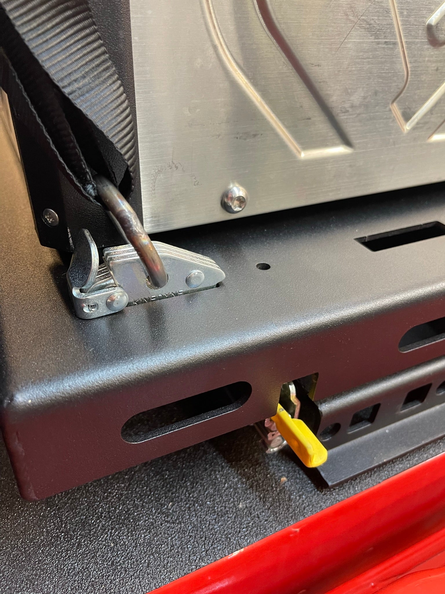 Close-up of the Ford Raptor modular bed organizer showing the slide-out cargo tray and securing mechanisms.