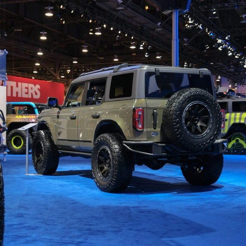 2021-2025 Ford Bronco showcasing custom fenders and offroad tires in a vibrant exhibition setting.