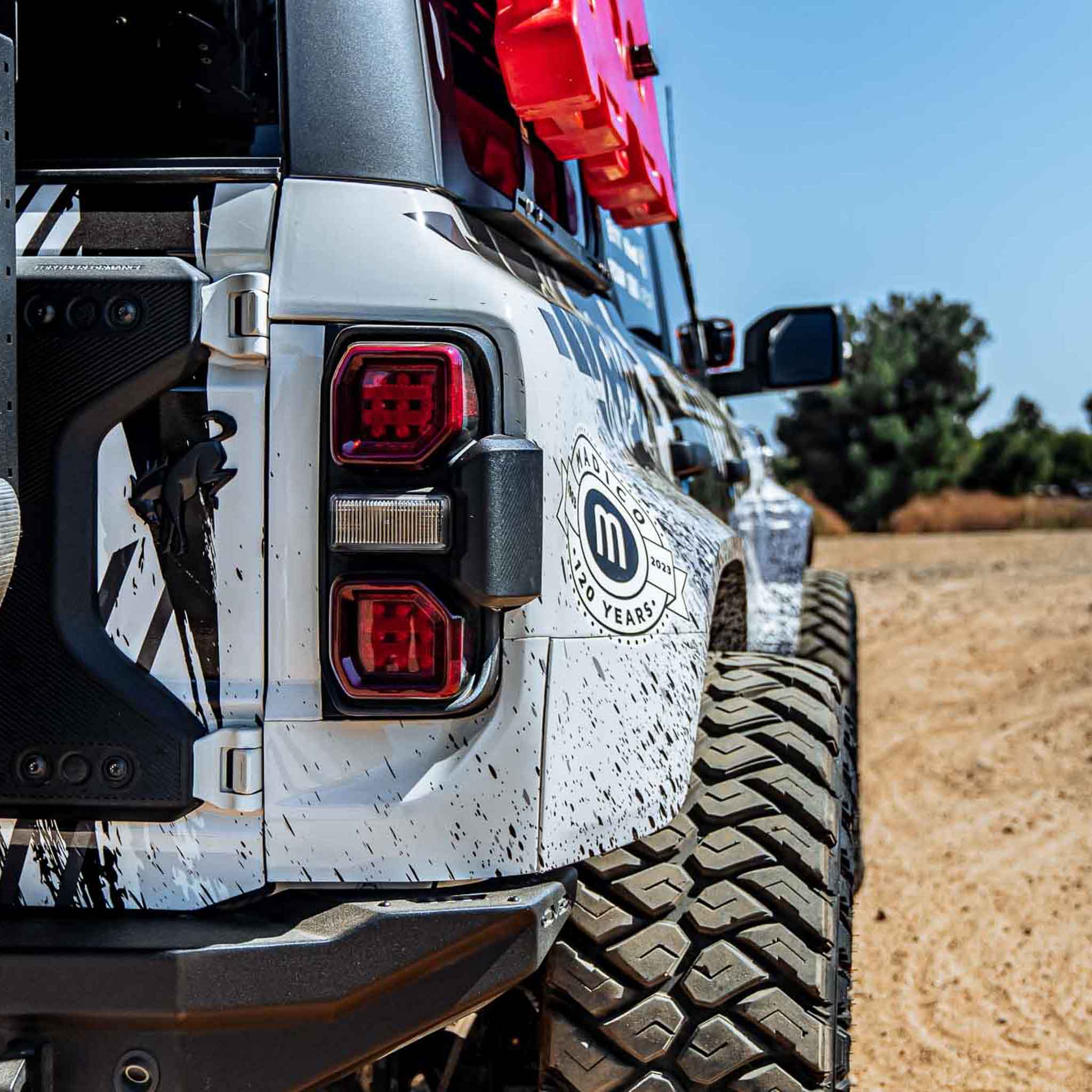 2022-2025 Ford Bronco Raptor showcasing a rear quarter kit with rugged design and off-road tires on a dirt trail.