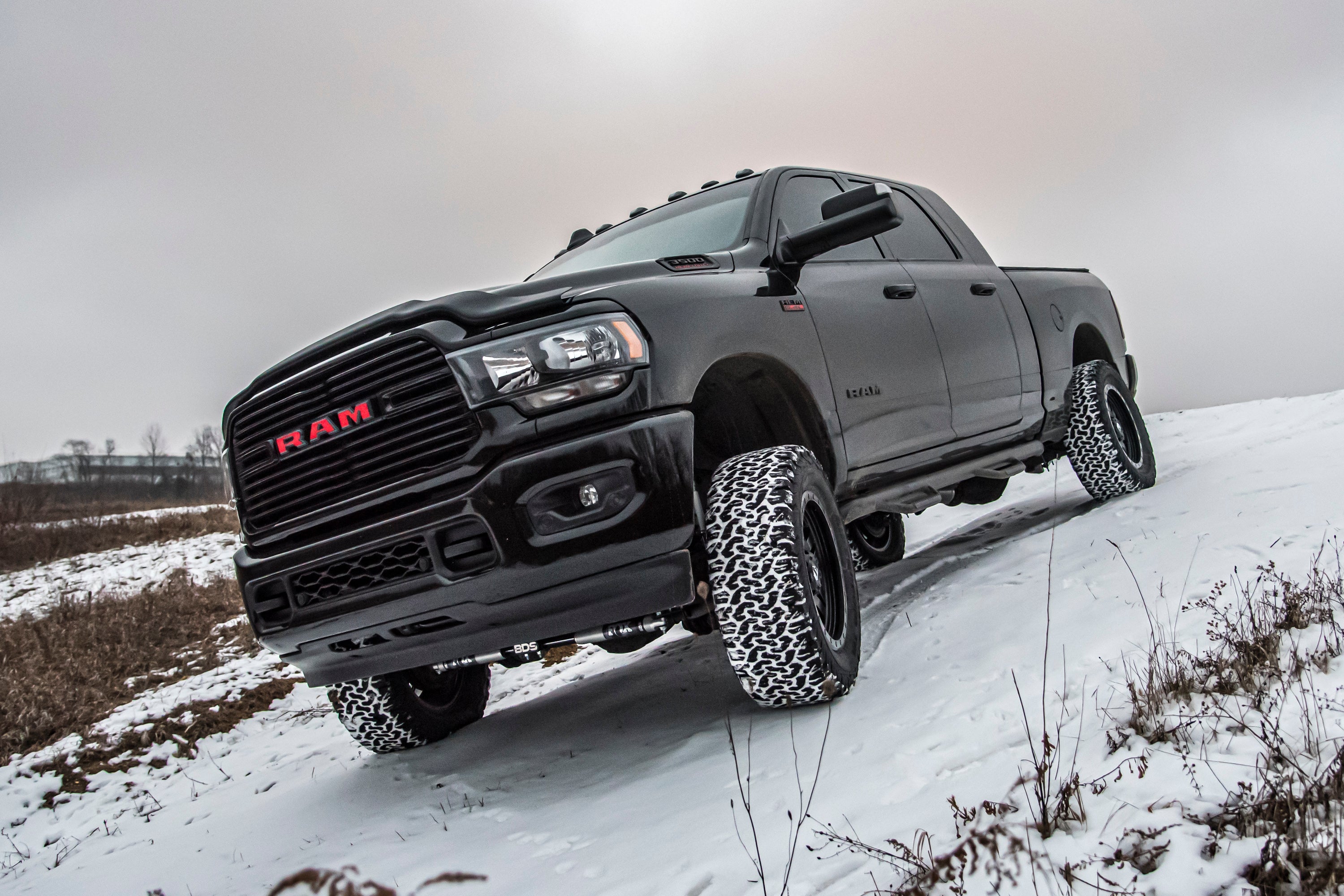 4-inch lift kit installed on a Ram 3500 with rear air ride, showcasing off-road capability in a snowy landscape.
