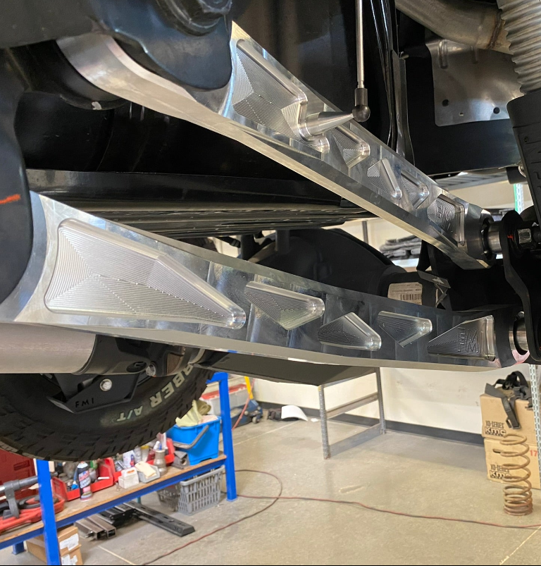 2025 Ram RHO rear suspension arm kit made of billet aluminum, showcasing its sleek design and durability under a truck.