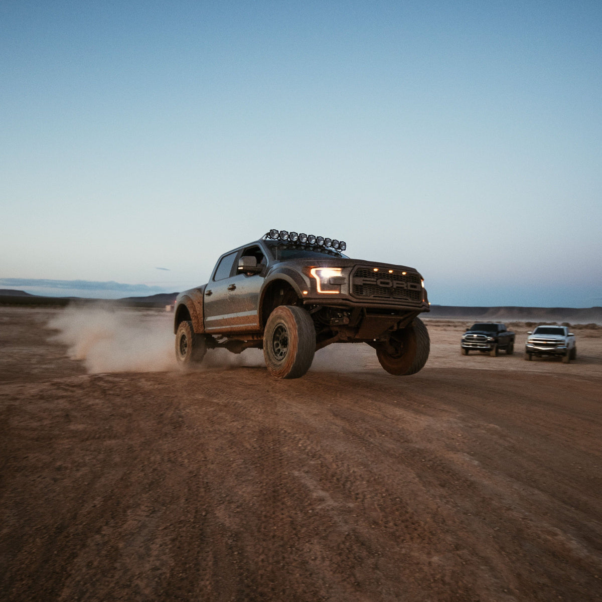 2017-2020 Ford Raptor fenders showcased on a truck jumping in a desert landscape, highlighting off-road capabilities.