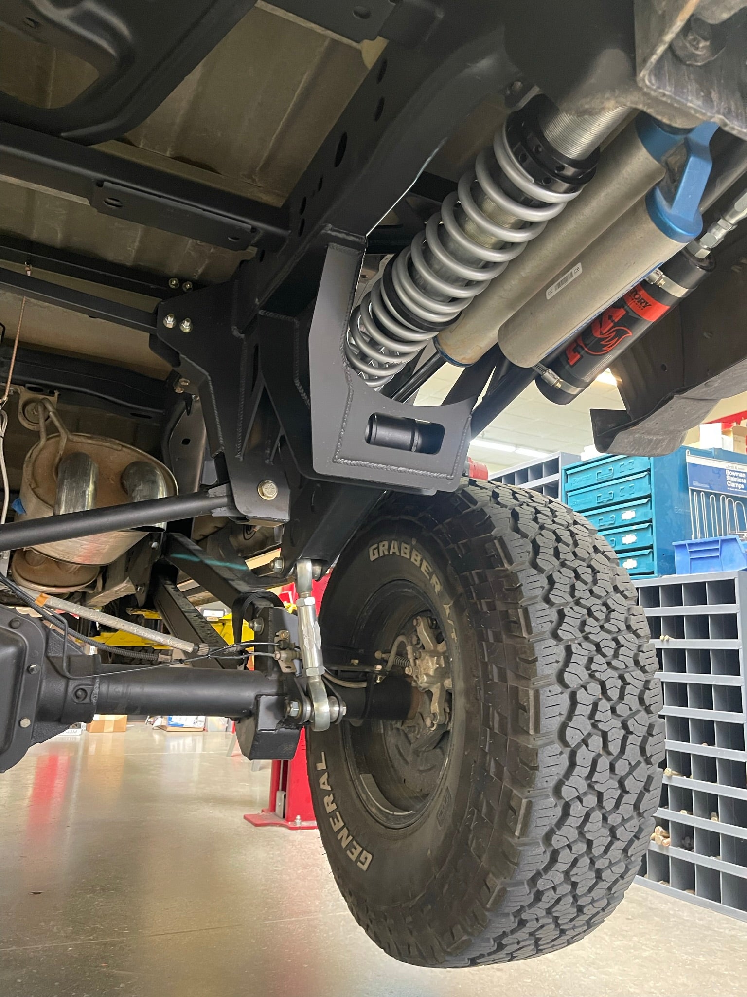 2021-2024 Raptor long travel rear suspension kit showcasing 19 inches of travel, installed on a truck with offroad tires.