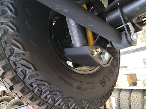 2021+ Bronco rear shock skid kit installed on a vehicle, showcasing the shock and tire for offroad protection.