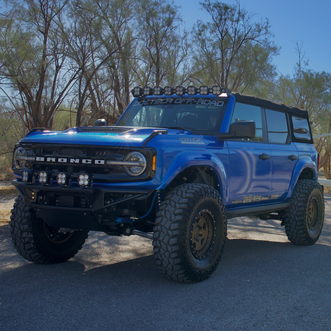 2021-2025 Ford Bronco with custom fenders, offroad lights, and rugged tires in a desert setting. Ideal for offroad enthusiasts.