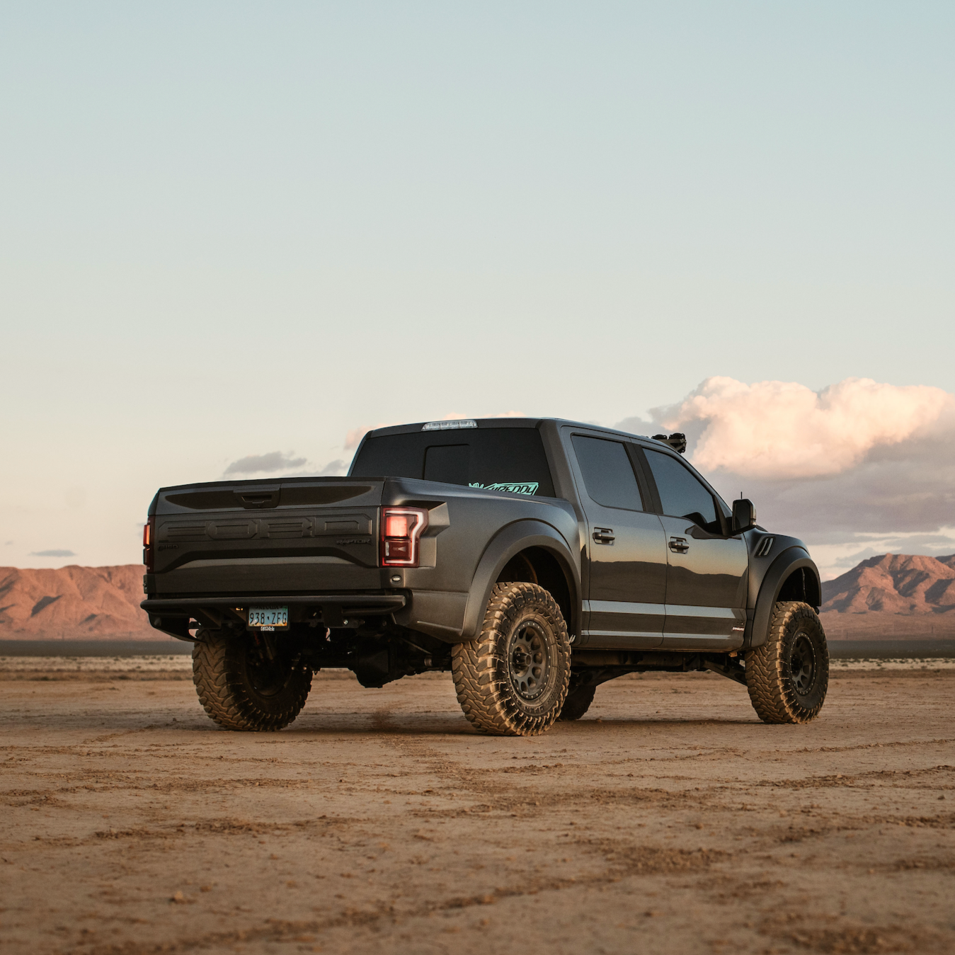 2017-2020 Ford Raptor with aftermarket bedsides, showcasing rugged off-road capability in a desert landscape.