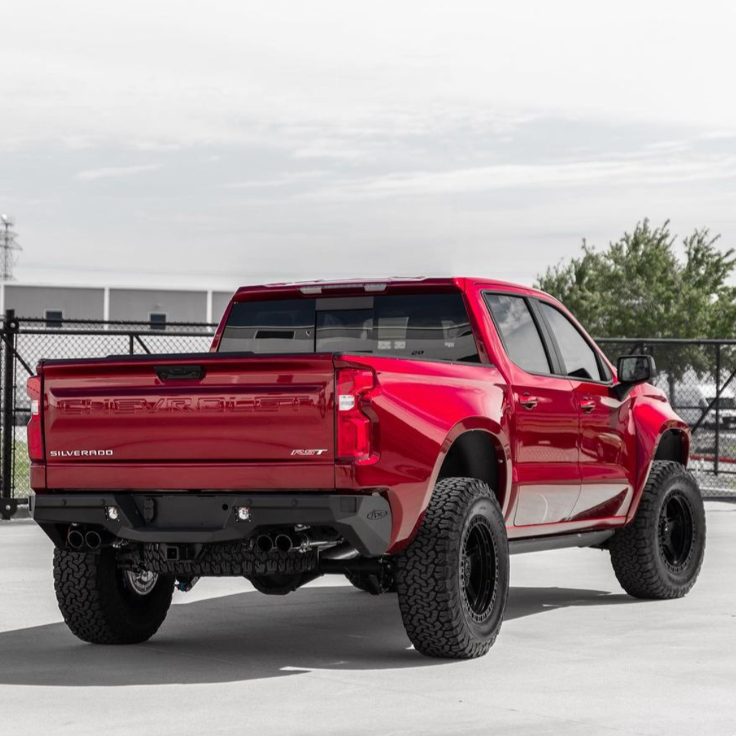 2019-2025 Chevrolet Silverado fenders showcasing a red truck with offroad tires in an outdoor setting.