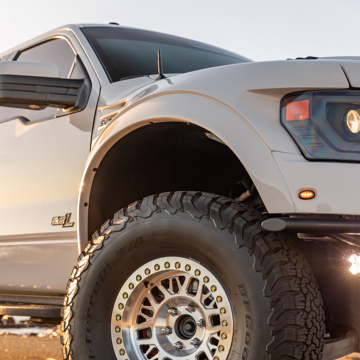 2010-2016 Ford Raptor fenders showcasing rugged design and fitment on a lifted truck with offroad tires.