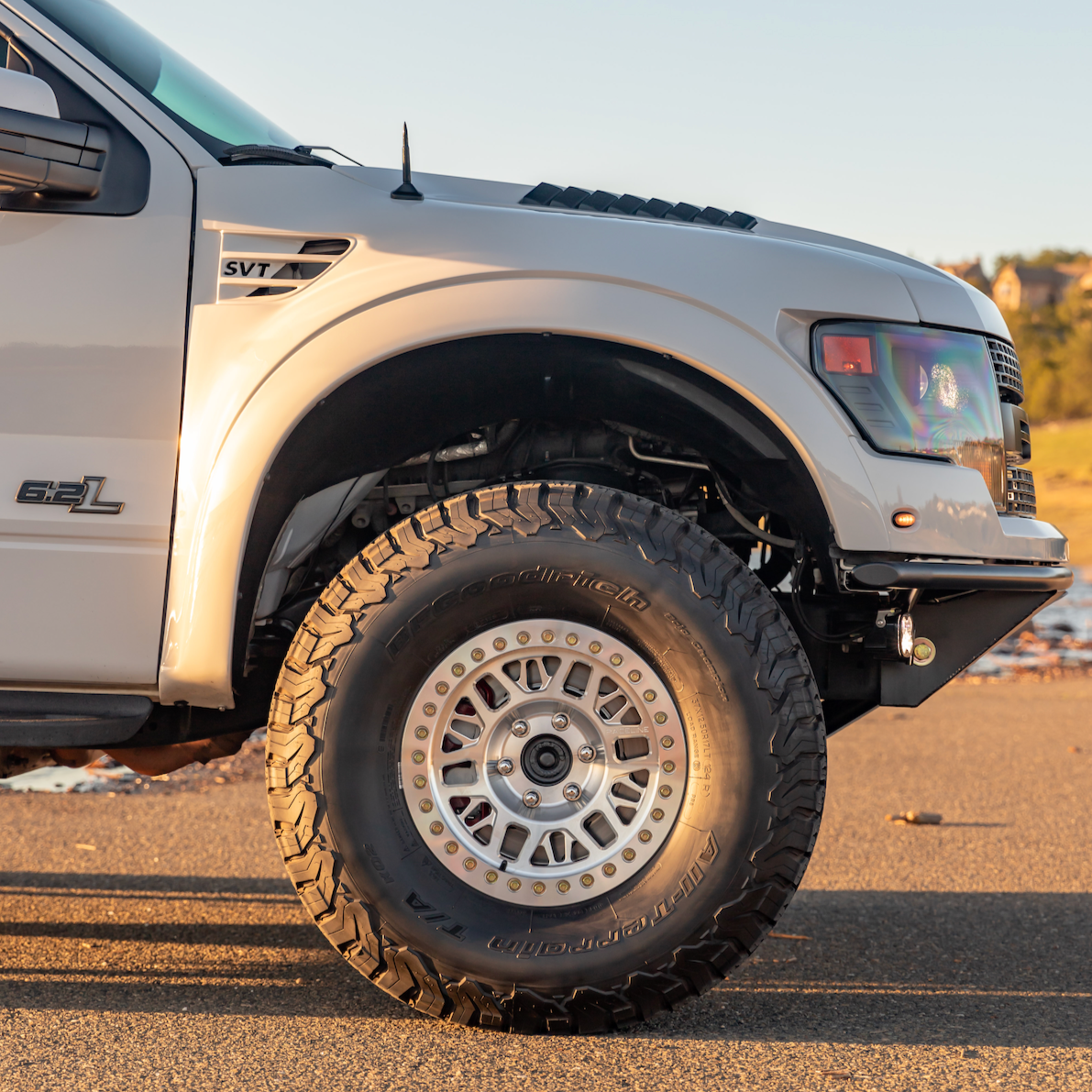 2010-2016 Ford Raptor fenders showcasing rugged design and fitment with large off-road tires. Ideal for enhanced performance.