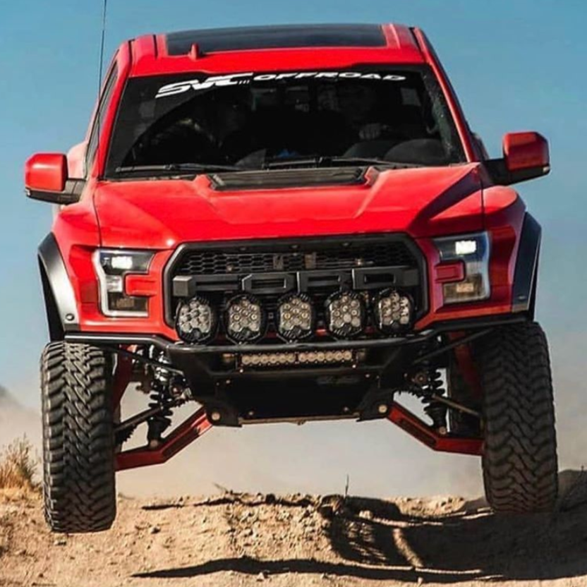 2017-2020 Ford Raptor fenders on a red truck showcasing offroad capabilities in a rugged terrain setting.