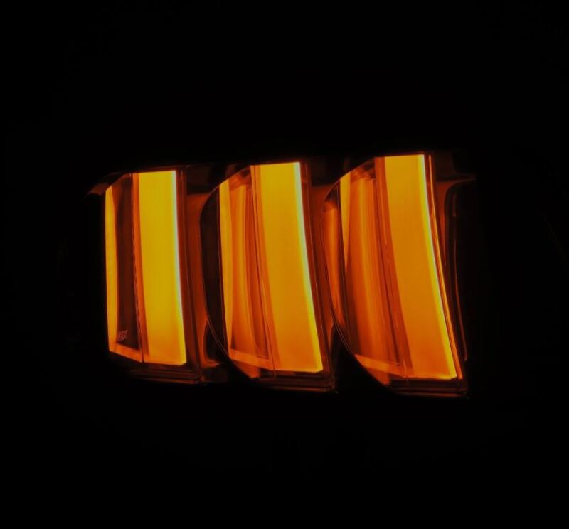 AlphaRex NOVA-Series prismatic LED tail lights for 2015-2023 Ford Mustang in black-clear finish, showcasing bright orange illumination.