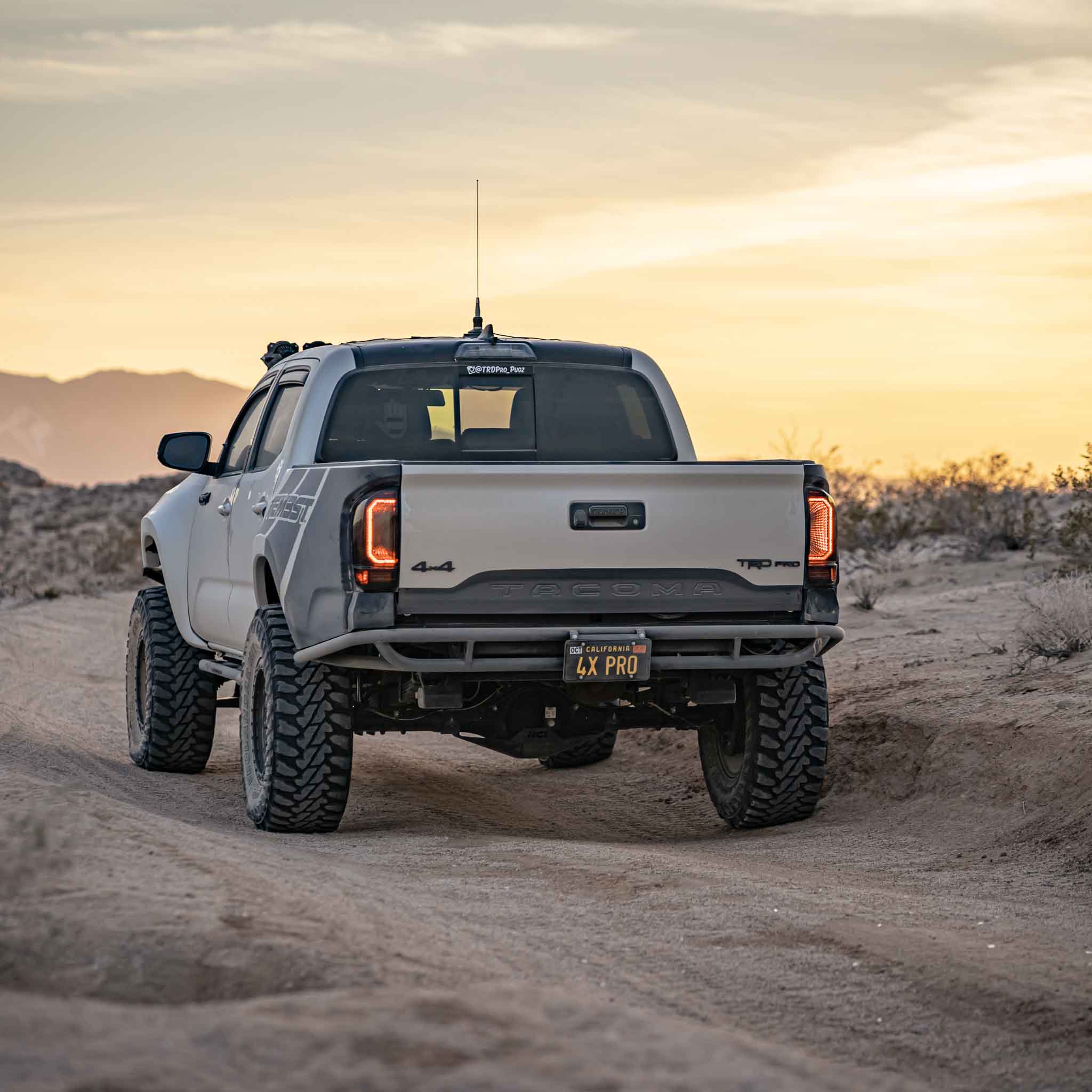 2016-2023 Toyota Tacoma with aftermarket bedsides, showcasing rugged off-road capability in a desert landscape.