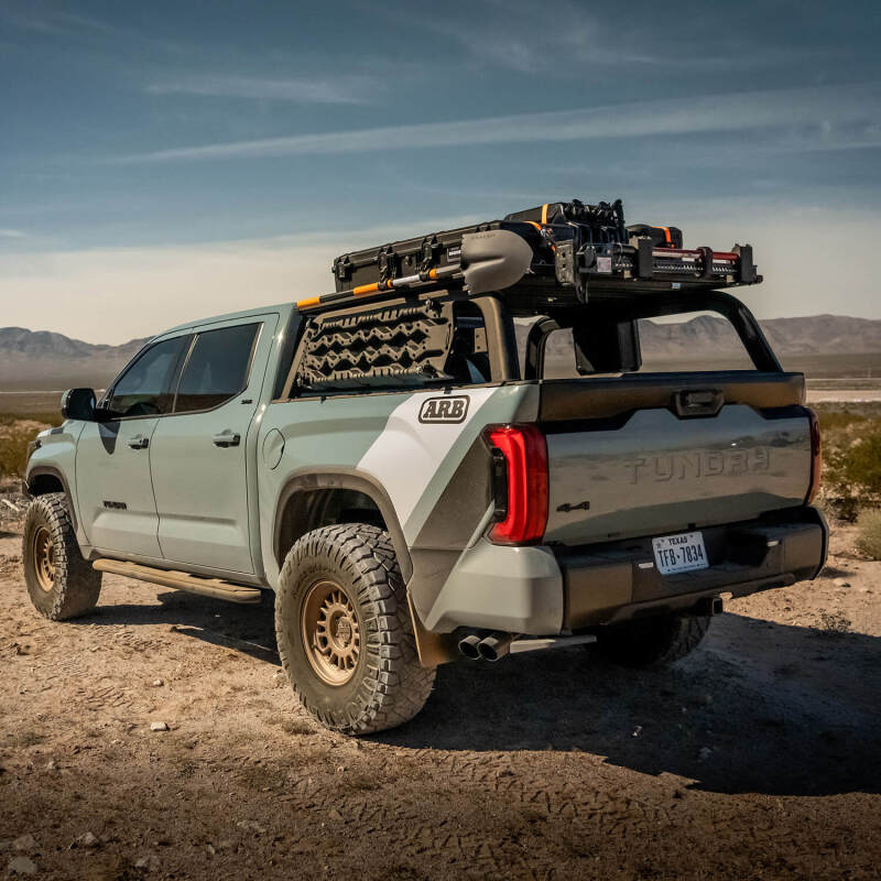 Toyota Tundra with ARB bed rack, showcasing offroad gear and rugged terrain, ideal for adventure enthusiasts.