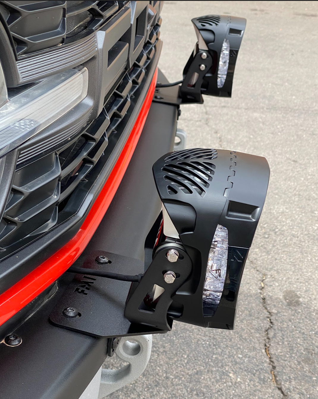 Bronco Raptor light mount brackets installed on a stock modular bumper, designed for 2022-2024 models, showcasing a sleek black finish.