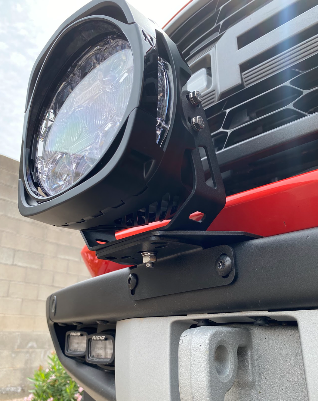 Light mount brackets for 2022-2024 Bronco Raptor, securely holding a round light on a stock modular bumper.