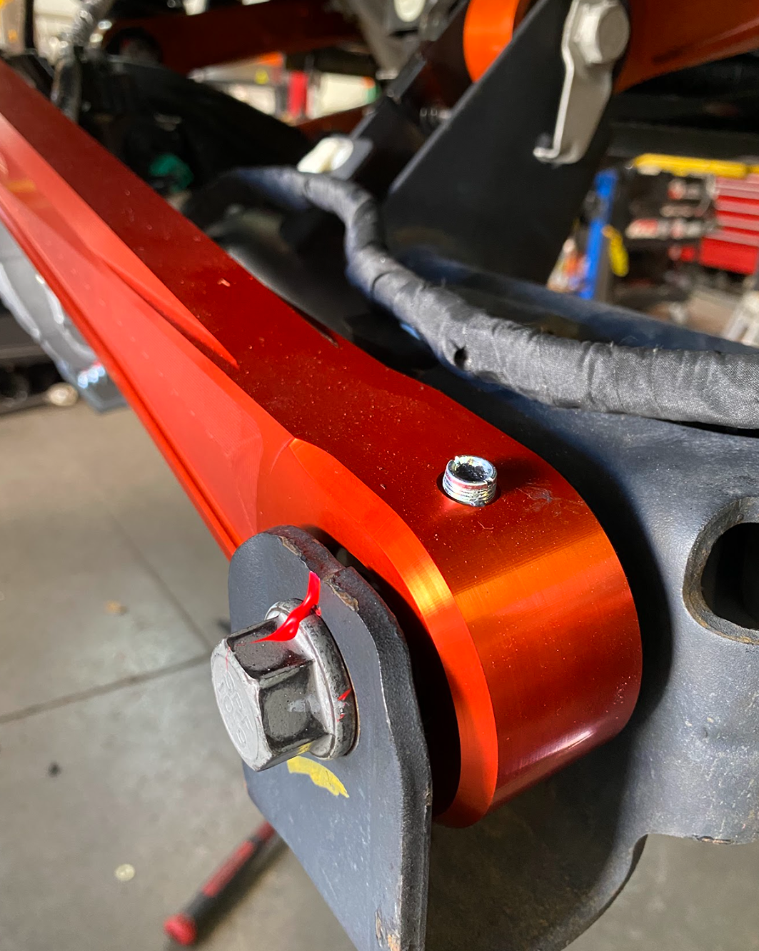 2022+ Bronco Raptor billet panhard bar featuring an ultra-flex joint, showcasing its durable orange finish and precision engineering.