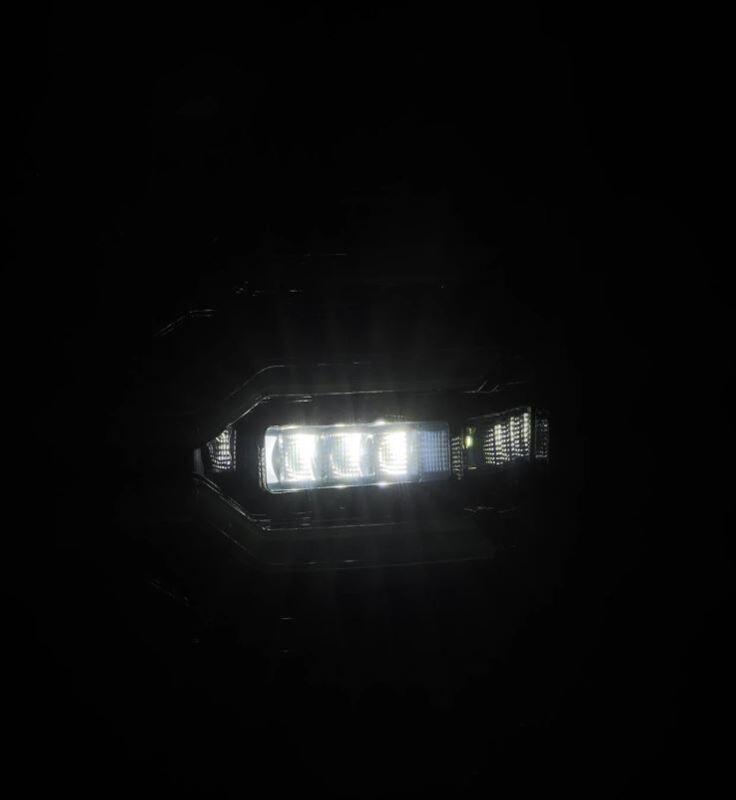AlphaRex Luxx Series LED tail lights for 07-13 GMC Sierra models in Alpha Black, showcasing bright LED illumination.