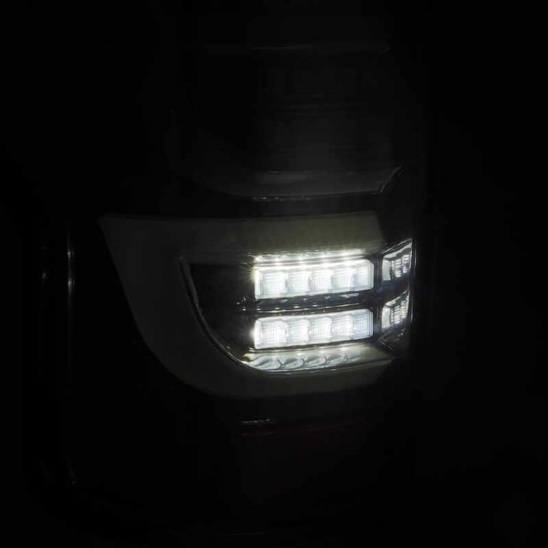 AlphaRex LUXX-Series LED tail lights for 07-13 Toyota Tundra in alpha-black finish, showcasing bright LED illumination.
