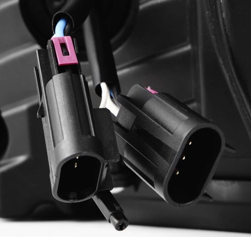 Close-up of AlphaRex projector headlights connectors for 20-22 Ford F150, showcasing wiring and plug design for installation.