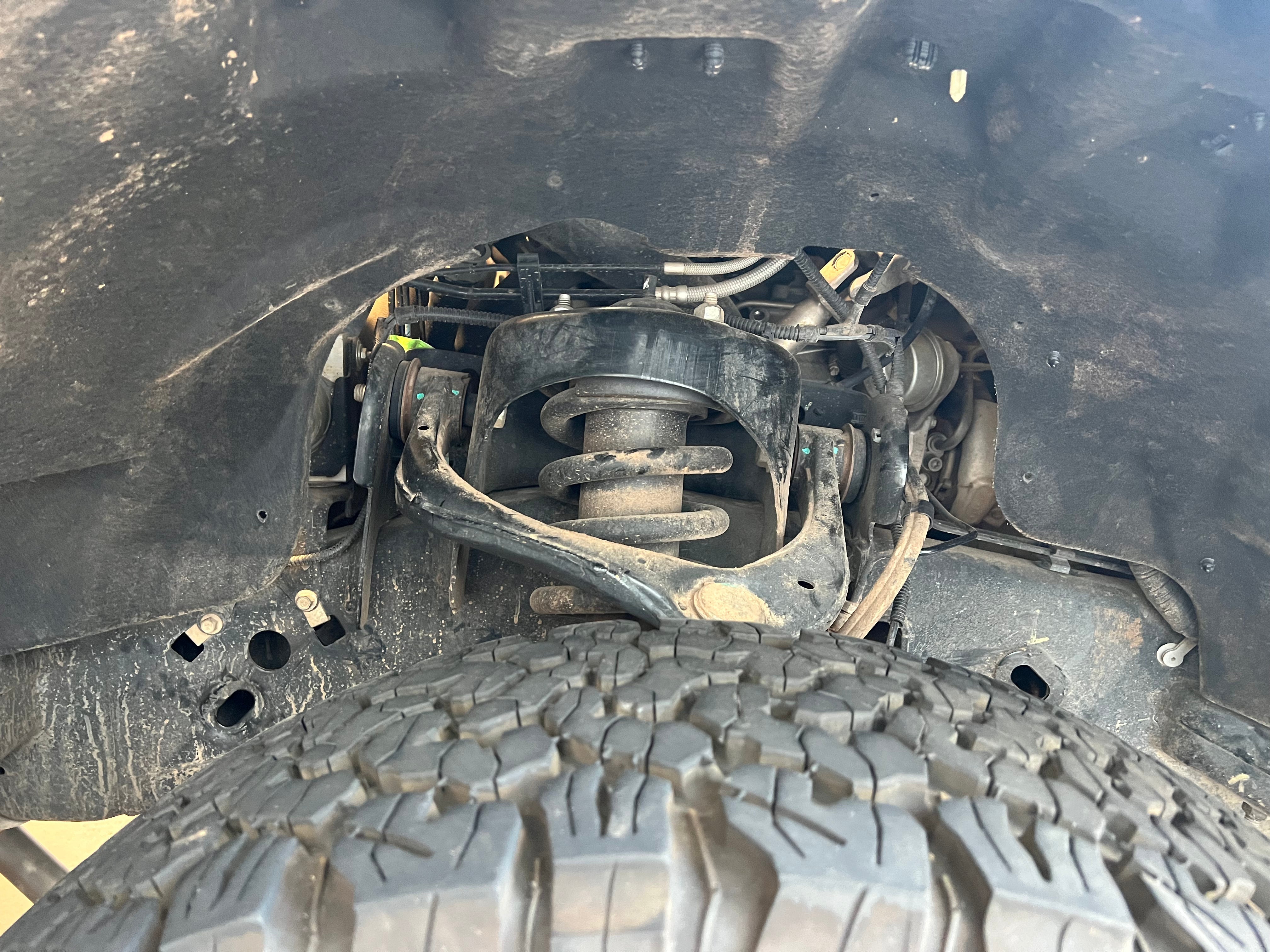 Splash guards for 2015-2020 Ford F150 EcoBoost, showcasing undercarriage components and tire detail.