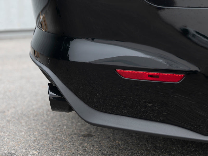 A close-up of the afe MACH Force-Xp axle-back exhaust system on a Ford Mustang GT, showcasing the sleek black exhaust tip.