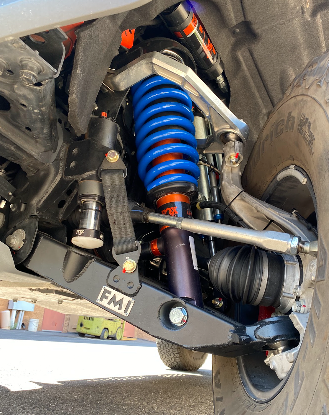2022 Bronco Raptor mid travel front suspension kit showcasing blue coilovers and heavy-duty components for off-road performance.