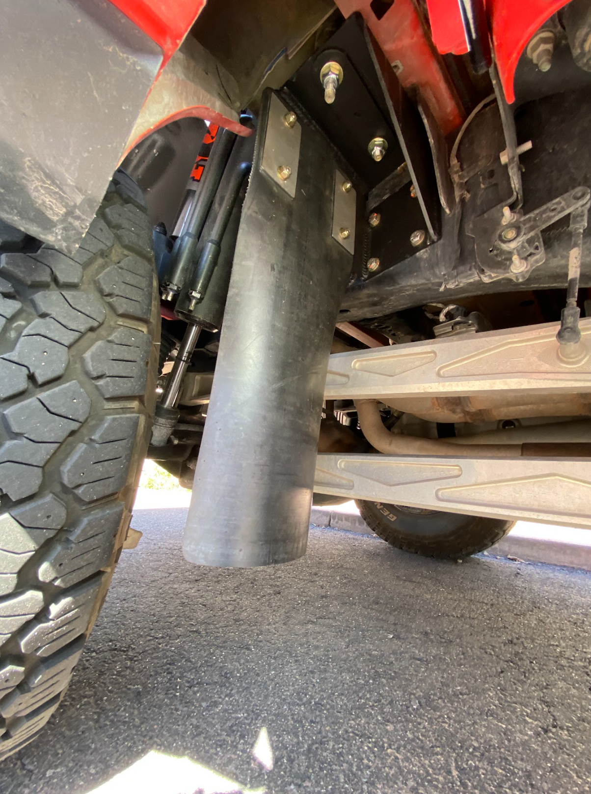 Rear shock guard mud flap frame mount kit for 2017-2024 Gen 2 and Gen 3 Raptor, showcasing durable installation under the vehicle.