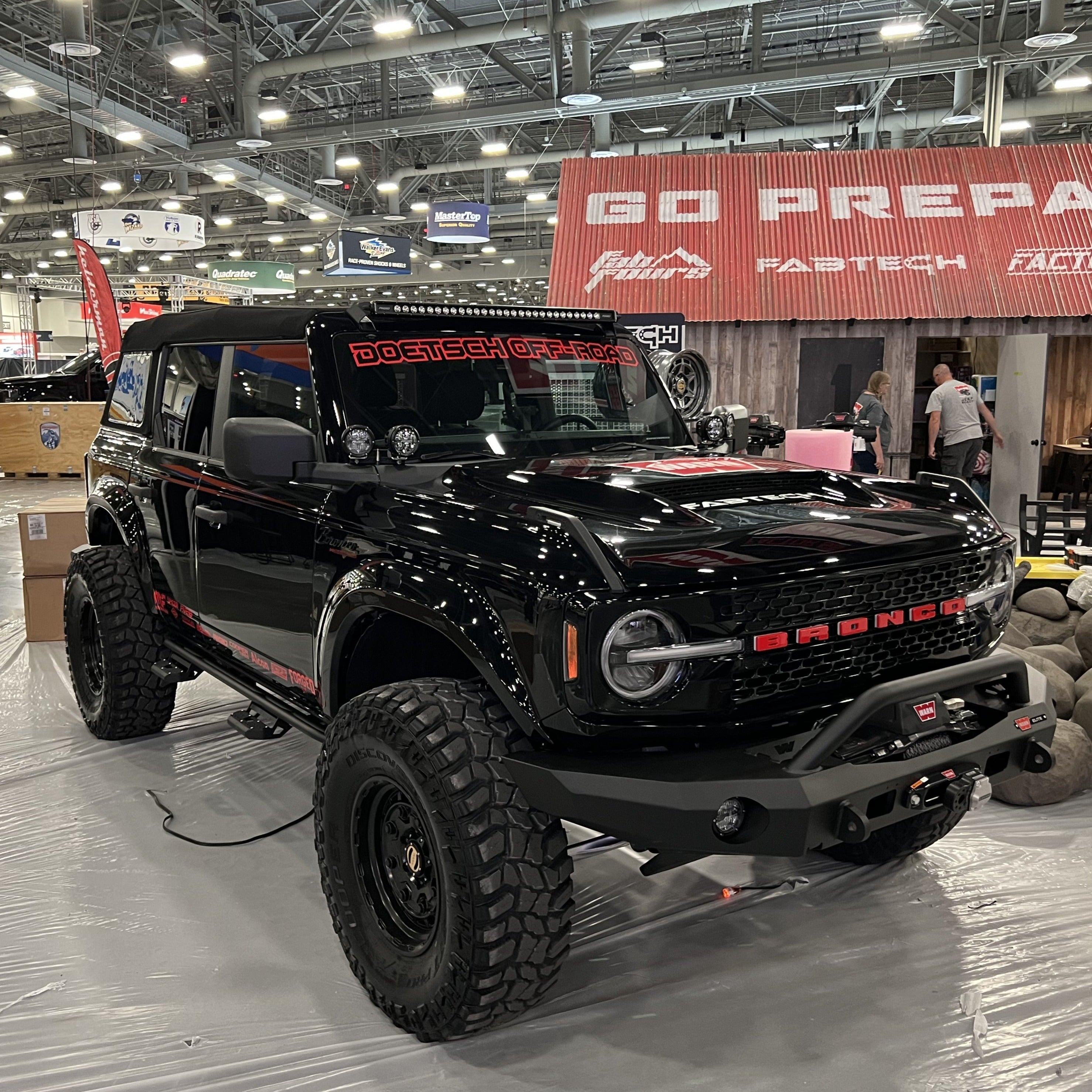 2021-2025 Ford Bronco fenders showcased on a modified black Bronco at an offroad expo, highlighting rugged design and durability.