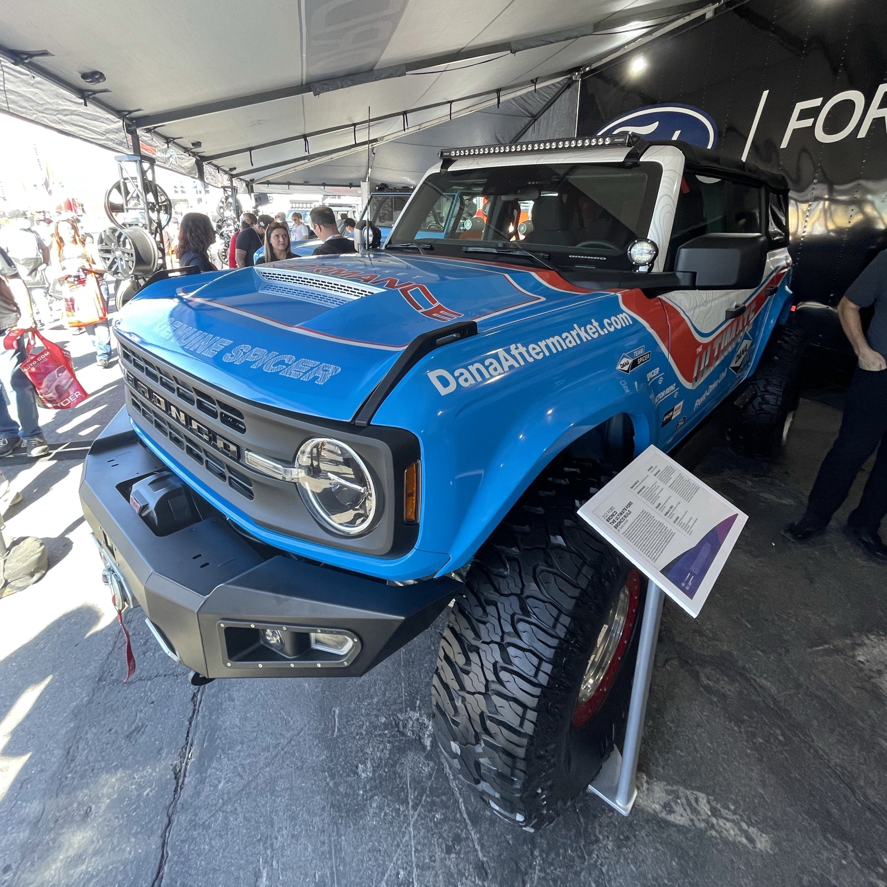 2021-2025 Ford Bronco with a Ram Air Hood showcasing a bold blue design and offroad tires at an automotive event.