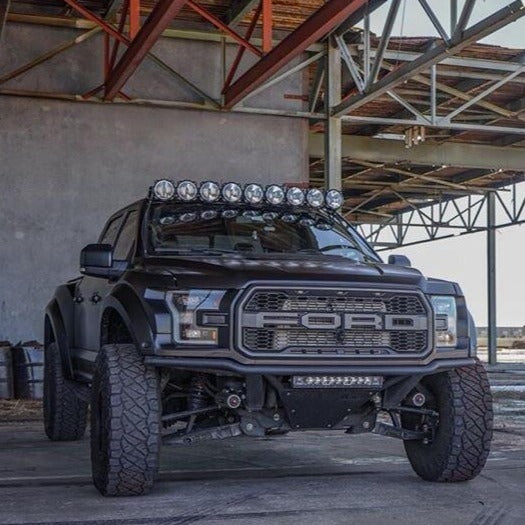 2017-2020 Ford Raptor fenders showcased on a rugged truck with off-road lights in an industrial setting.