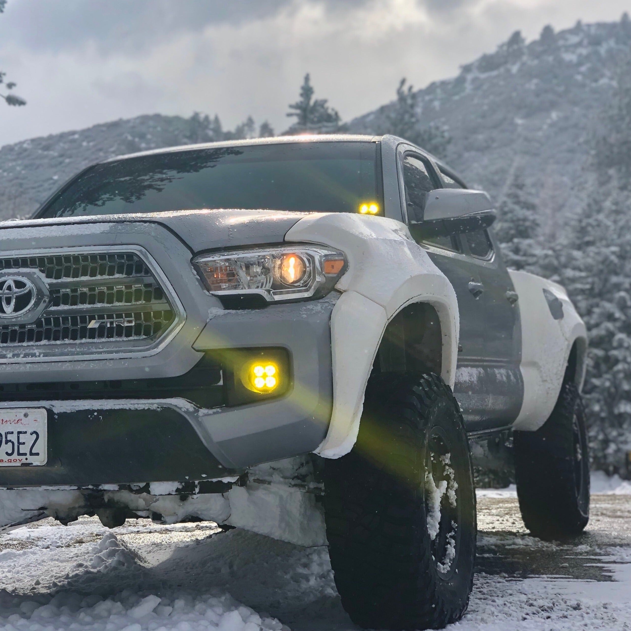 2016-2023 Toyota Tacoma with upgraded bedsides, showcasing rugged design in a snowy outdoor setting.