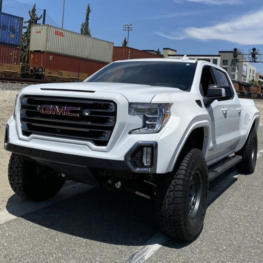 2019-2025 GMC Sierra fenders on a white truck with off-road tires, showcasing rugged design and enhanced performance.