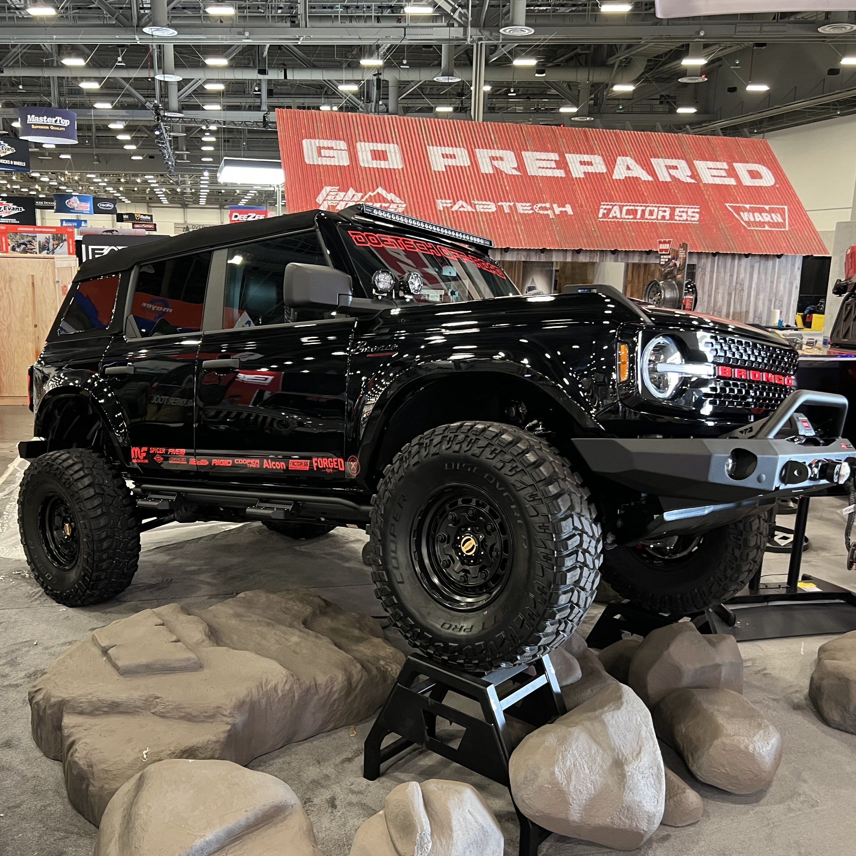 2021-2025 Ford Bronco with aftermarket fenders displayed on a stand, showcasing offroad capabilities and rugged design.