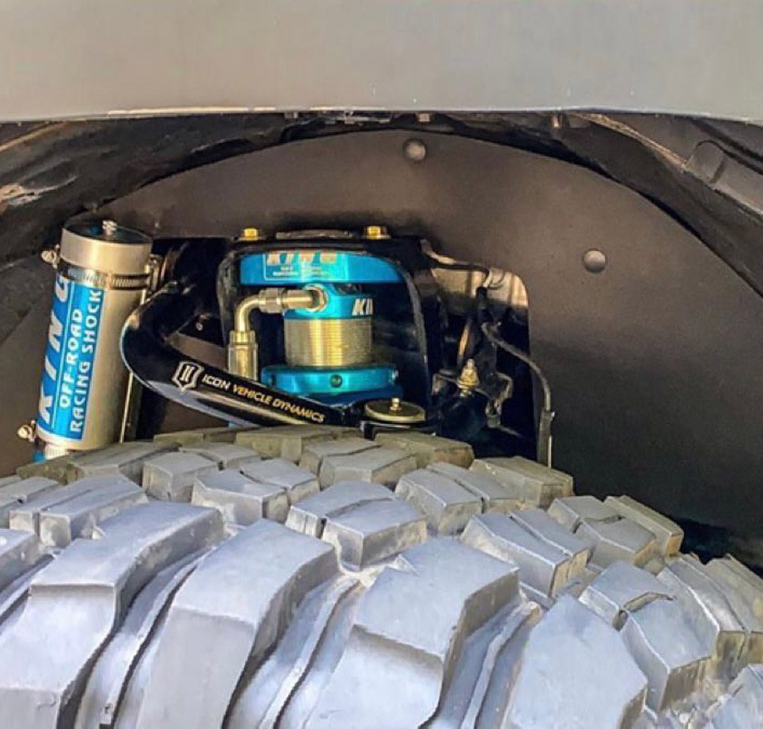 Lexus GX 470 splash guards installed, showcasing suspension components and rugged tire tread for offroad performance.