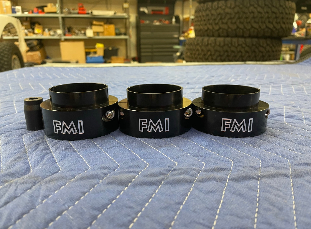 2025 Ram RHO 2 inch Front Leveling Kit featuring three black leveling spacers with FMI branding on a blue protective cover.
