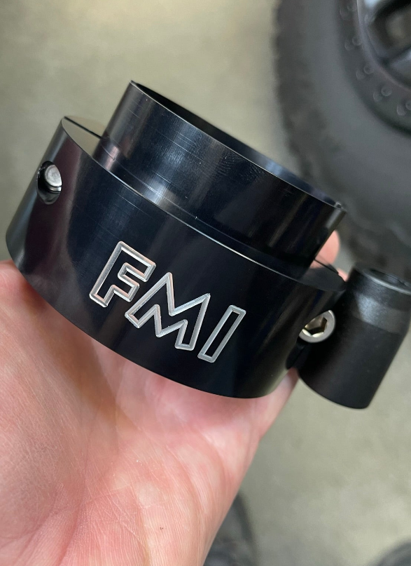 2025 Ram RHO 2 inch Front Leveling Kit component held in hand, showcasing black finish and FMI branding.