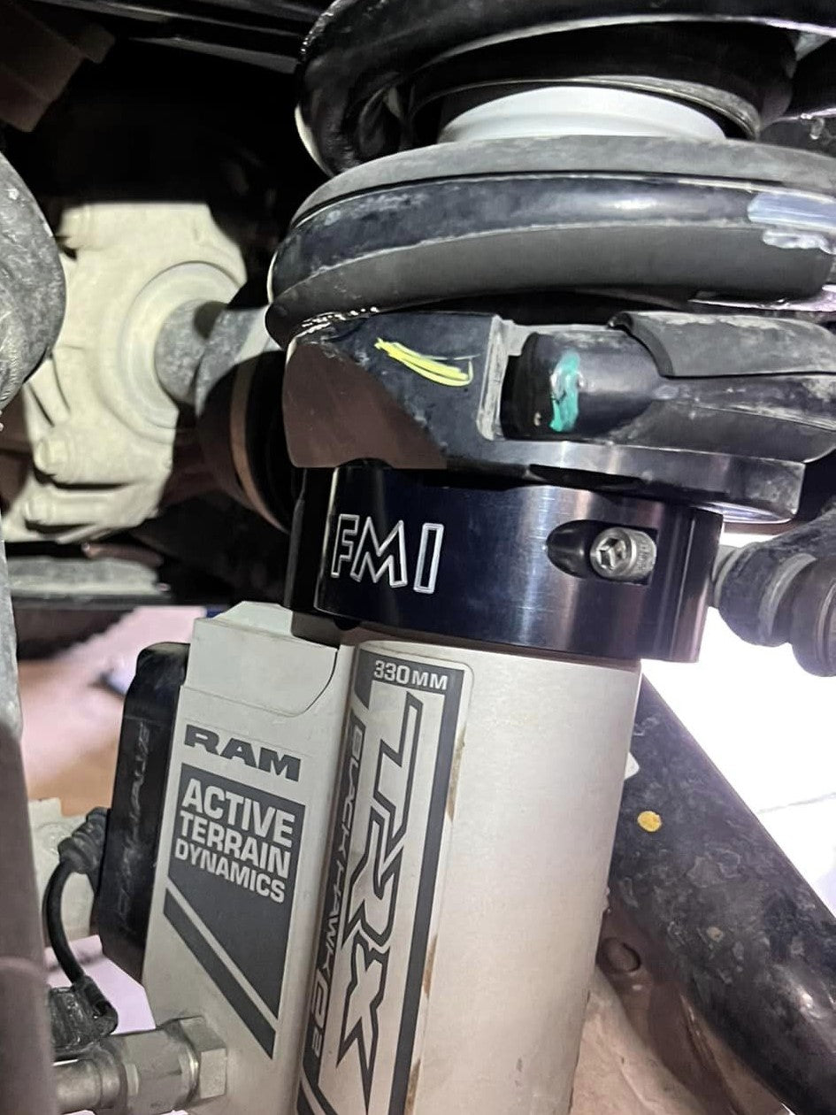 Close-up of the 2025 Ram RHO 2.5 inch front leveling kit, showcasing the shock absorber and leveling spacer components.