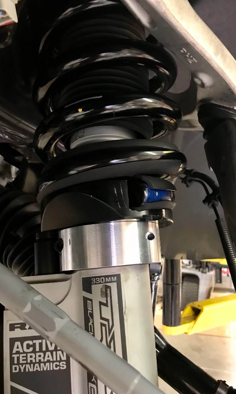 Close-up of the 2025 Ram RHO 2.5 inch front leveling kit showcasing the coil spring and shock absorber components.