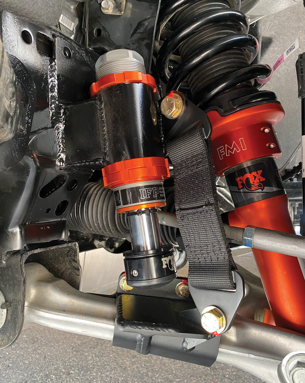 2024 Ranger Raptor front limit strap kit and bump stop installed on stock lower arm, showcasing suspension components.