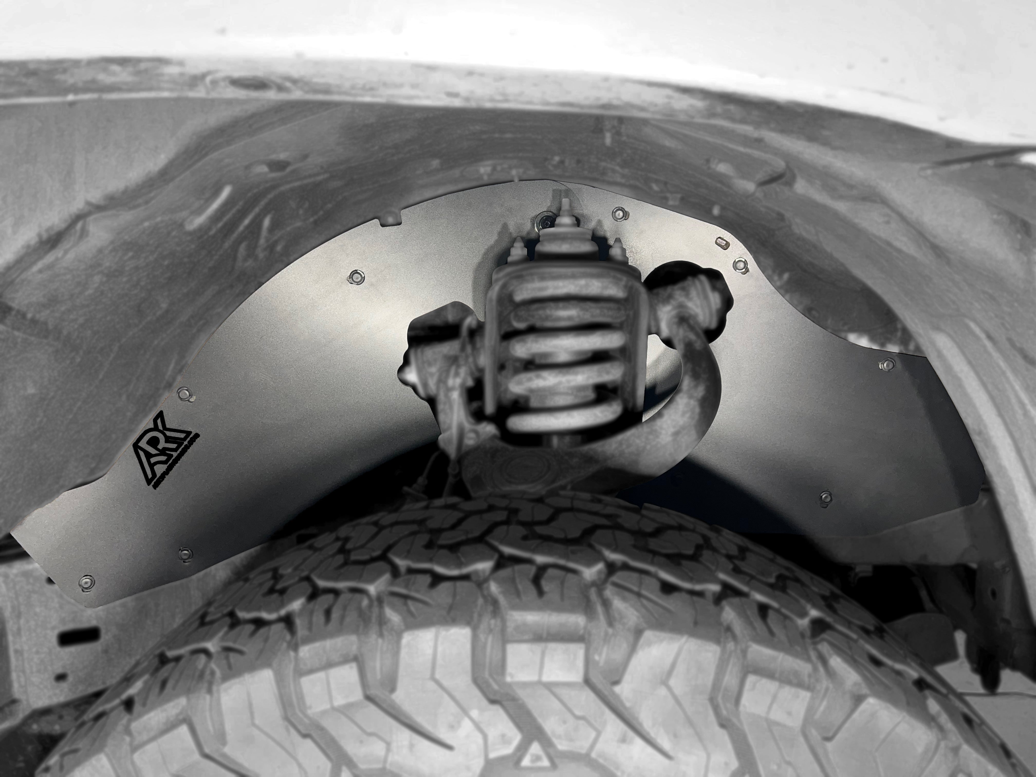 TriXpoly splash guards installed on a 2005-2015 Toyota Tacoma, protecting the wheel well and suspension components.